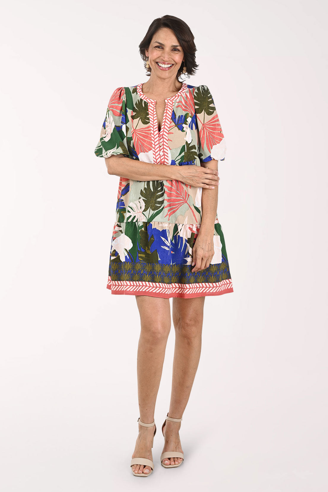 Woman wearing a colorful floral dress on a white background