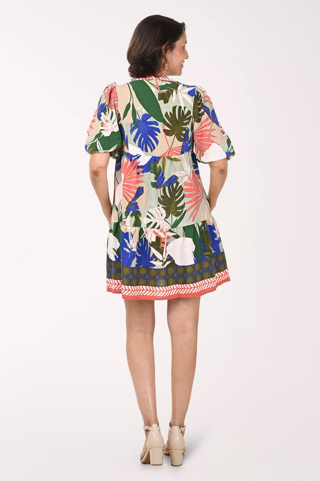 Woman wearing a colorful floral dress on a white background