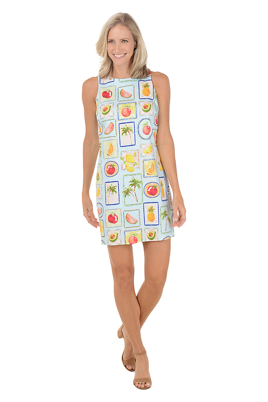 Woman wearing a sleeveless dress with fruit pattern on a white background