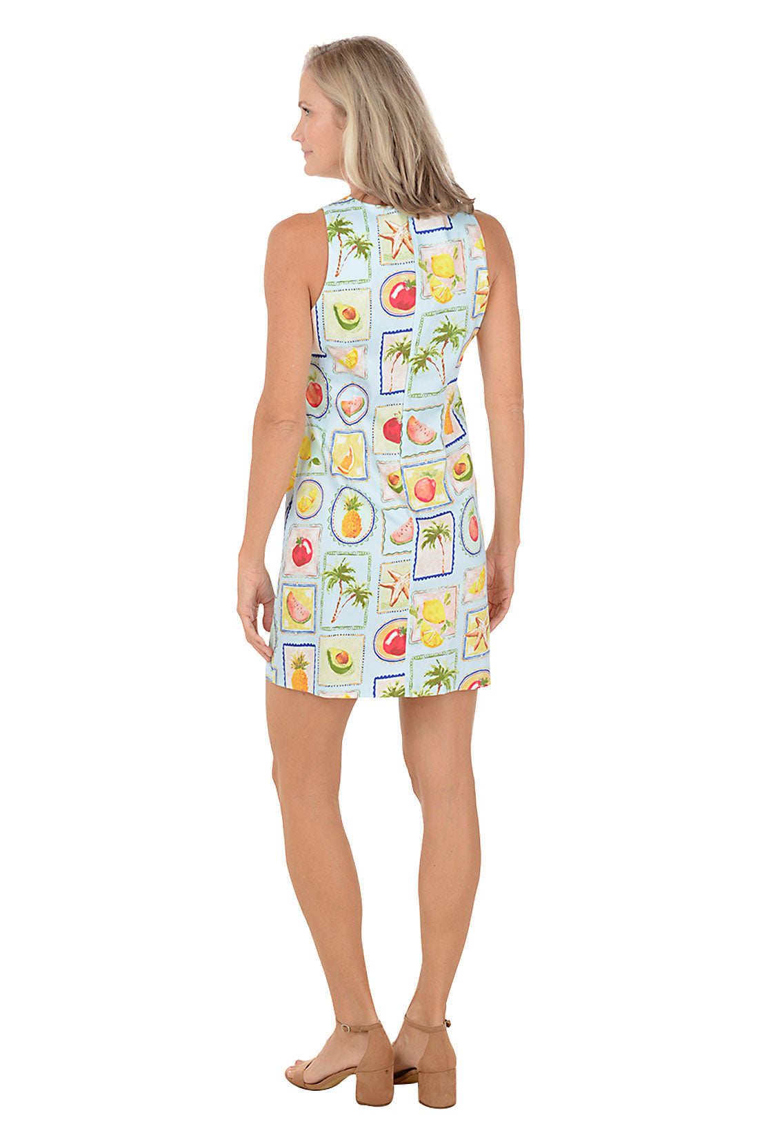 Woman wearing a sleeveless dress with fruit pattern on a white background
