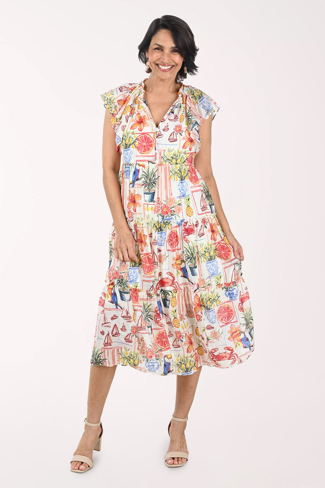 Woman wearing a colorful dress with a pattern of potted plants on a white background