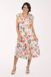 Woman wearing a colorful dress with a pattern of potted plants on a white background