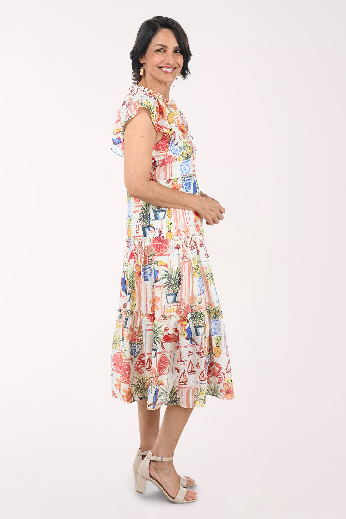 Woman wearing a colorful dress with a pattern of potted plants on a white background