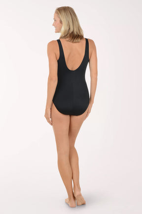 Woman wearing a black swimsuit with blue stripes on a white background. Back shot.