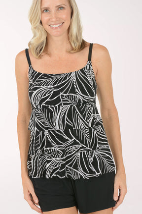 A woman wearing a black and white romper swimsuit cover-up.