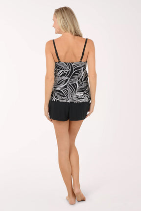 A woman wearing a black and white romper swimsuit cover-up.