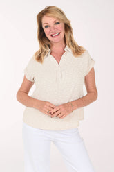 Woman wearing a beige short sleeve collared blouse