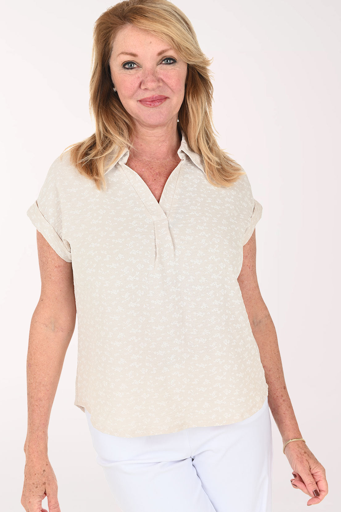 Woman wearing a beige short sleeve collared blouse