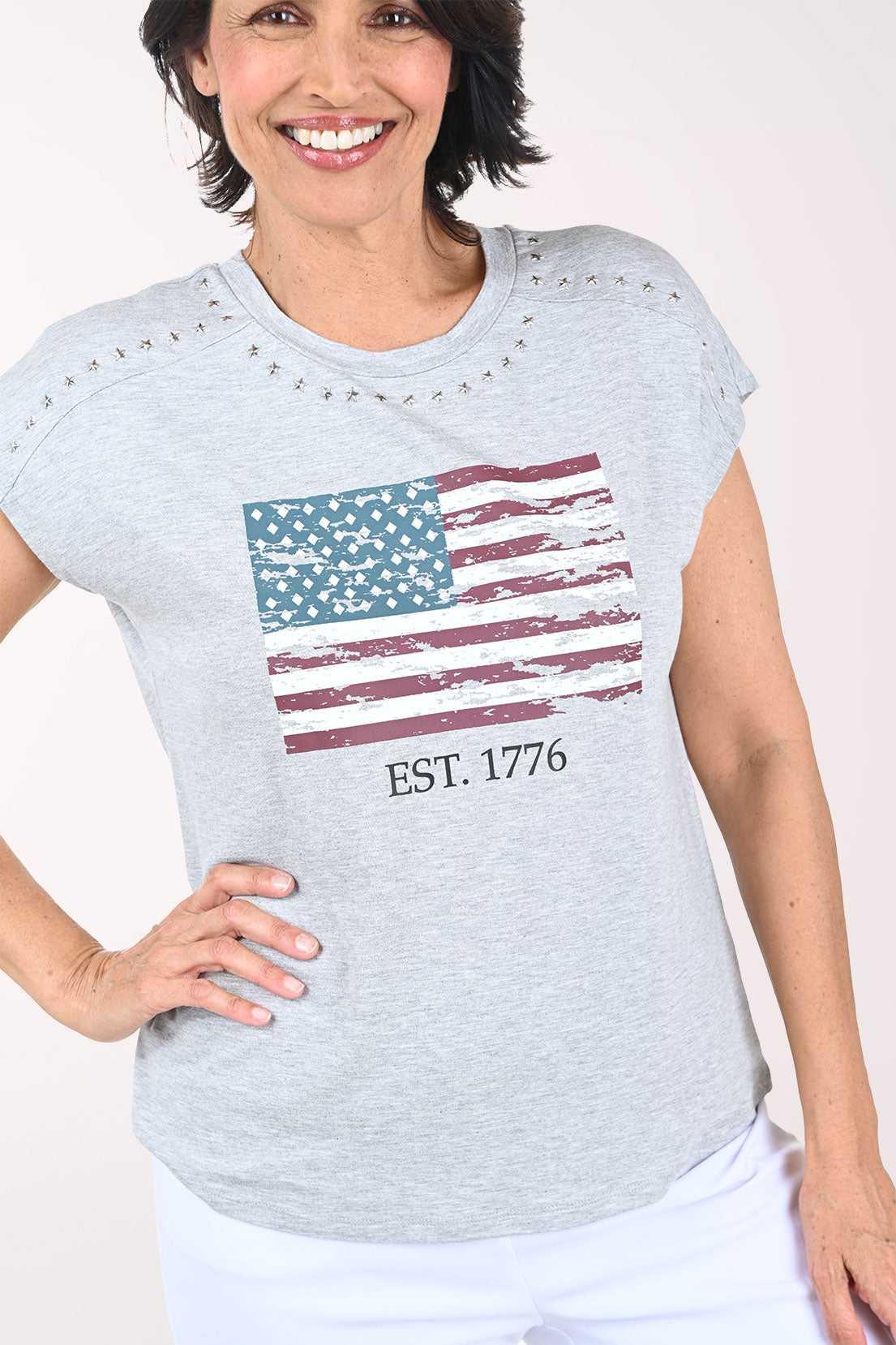 Woman wearing a gray t-shirt with an American flag design on a white background