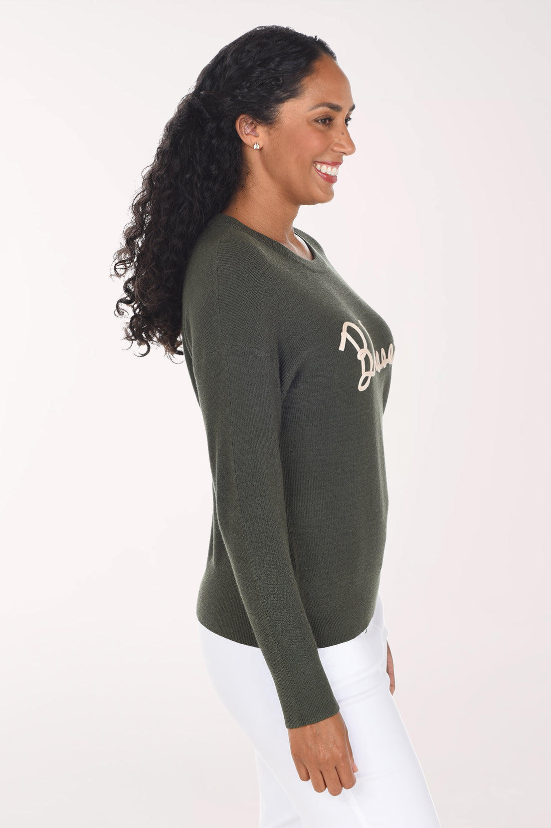 Side view of the olive green sweater showing the drop shoulder and long cuffed sleeve.