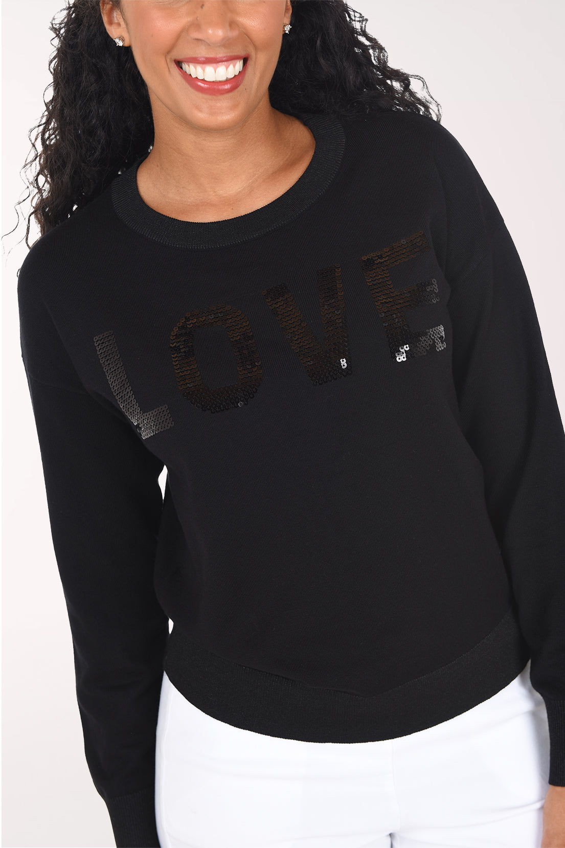 Close-up showing the tone-on-tone black sequined "Love" script and glitter ribbed crew neckline.