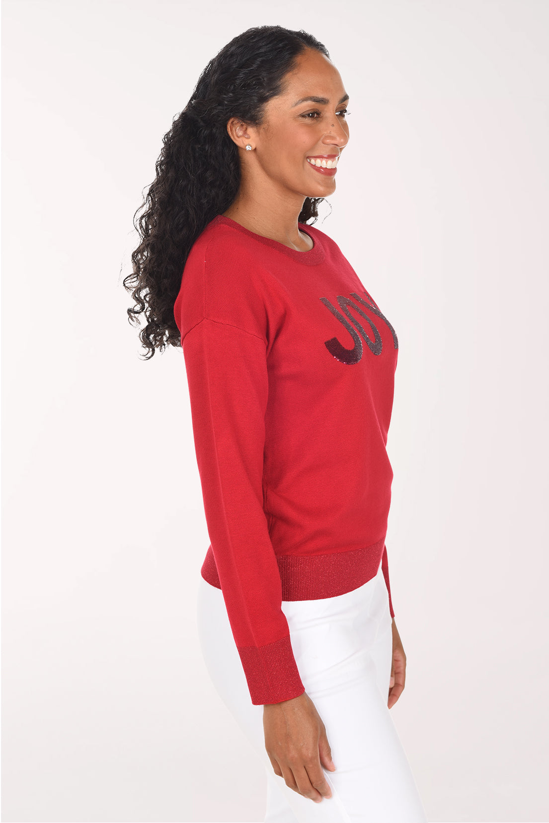 Side view of the red sweater showing the drop shoulder and long sleeves with ribbed cuffs.