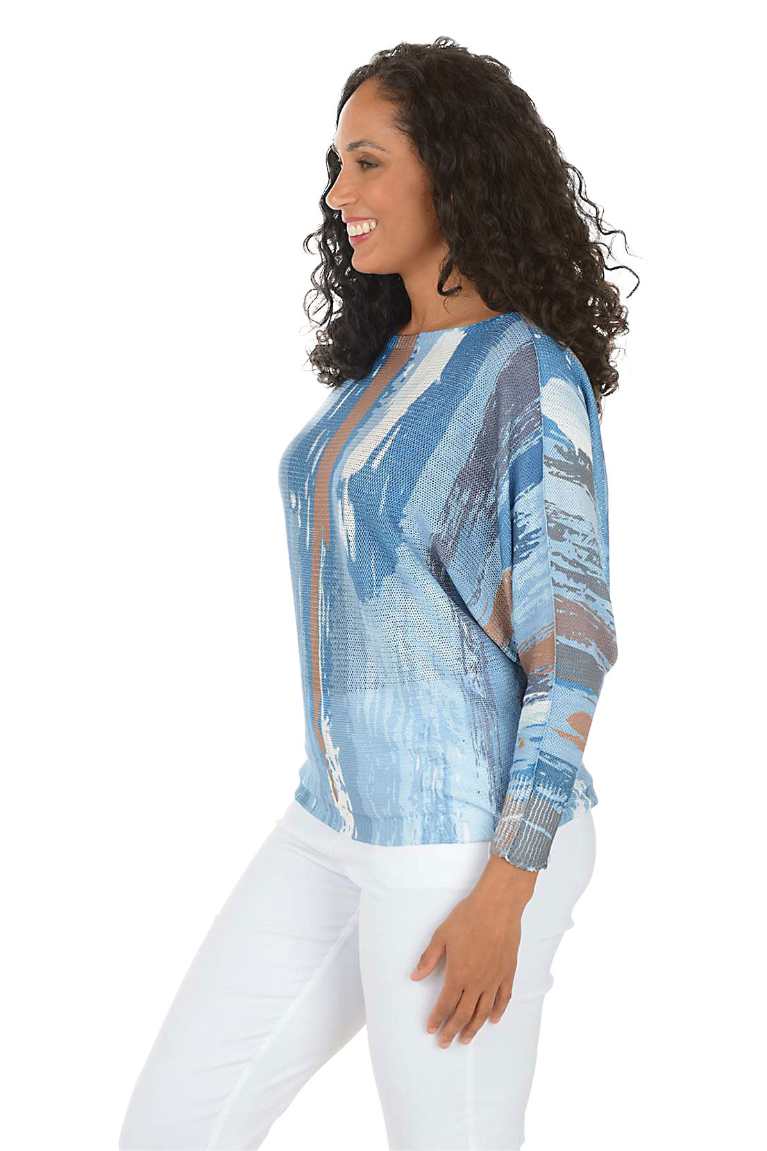 Woman wearing a blue patterned blouse with sheer panels on a white background. Side shot.