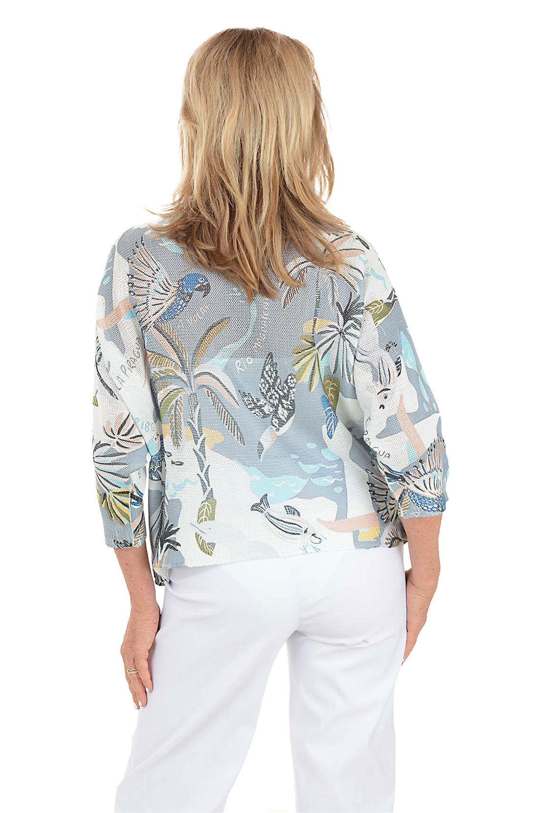 Woman wearing a patterned blouse with a white background. Back shot.