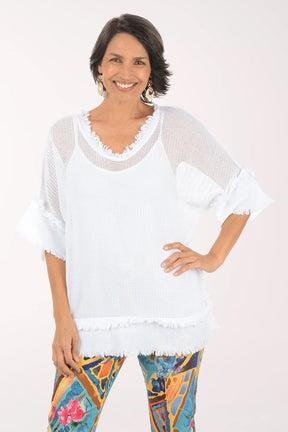 Woman wearing a white top and colorful pants on a white background
