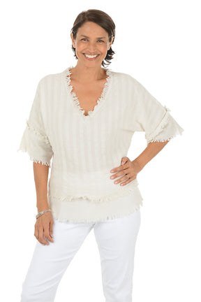 Woman wearing a beige blouse with ruffled details on a white background