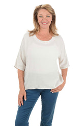 Woman wearing a white blouse and blue pants on a white background.
