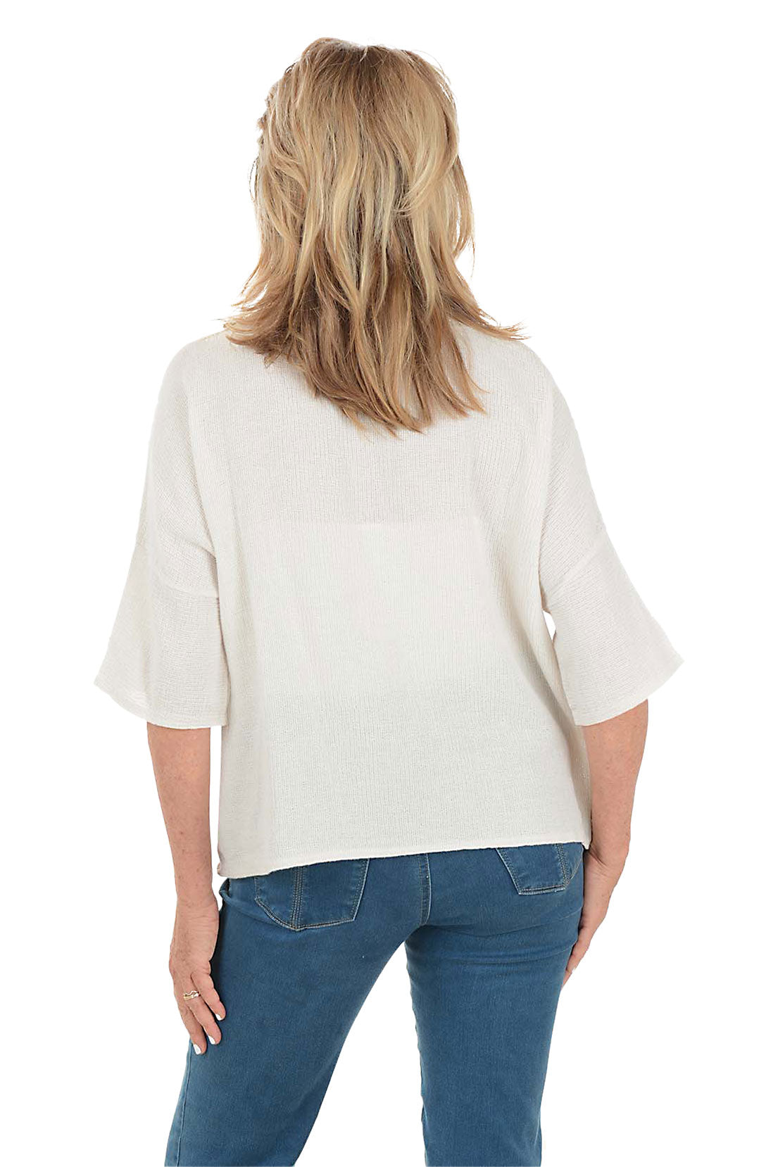 Woman wearing a white blouse and blue pants on a white background. Back shot.