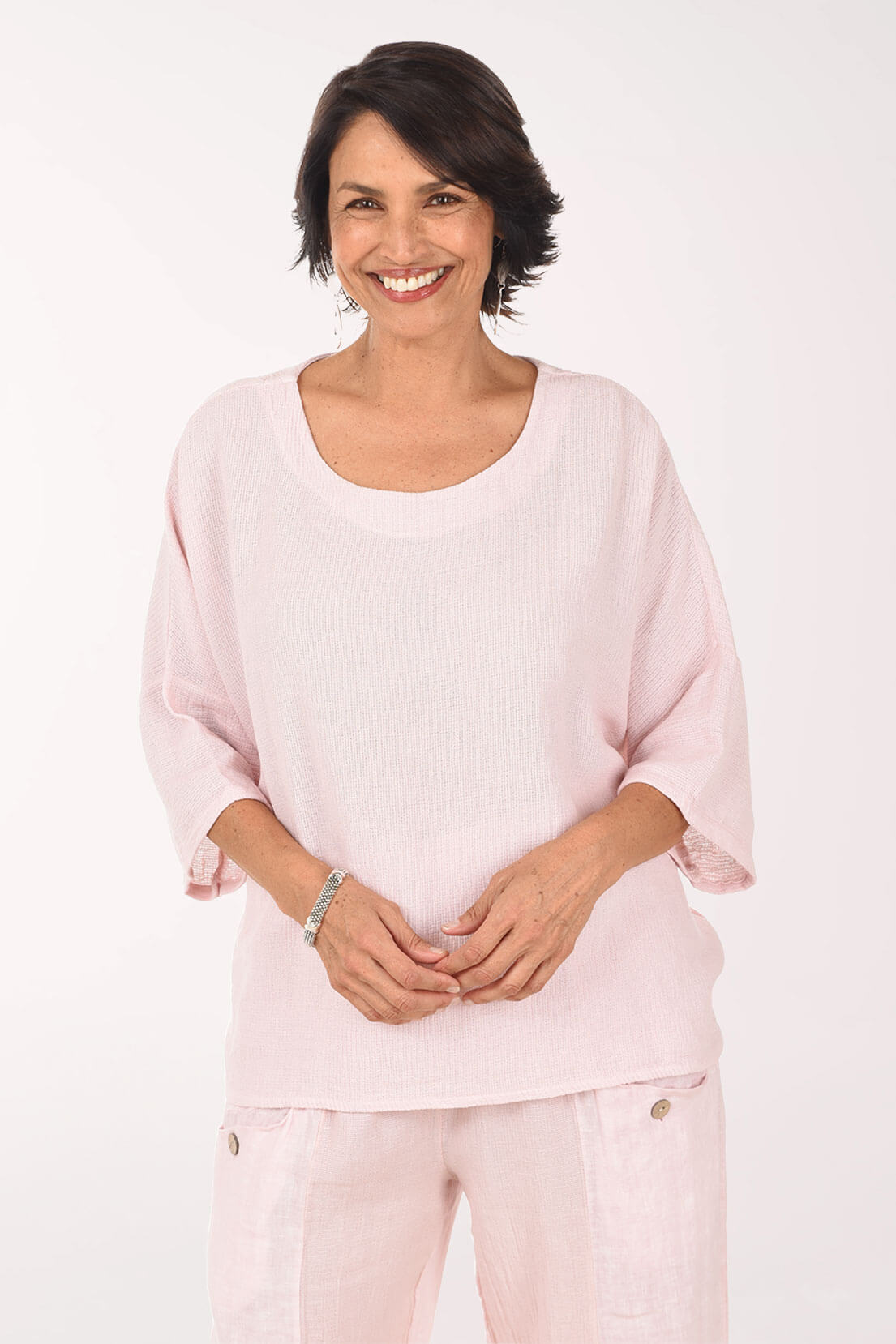 Woman wearing a light pink outfit on a white background