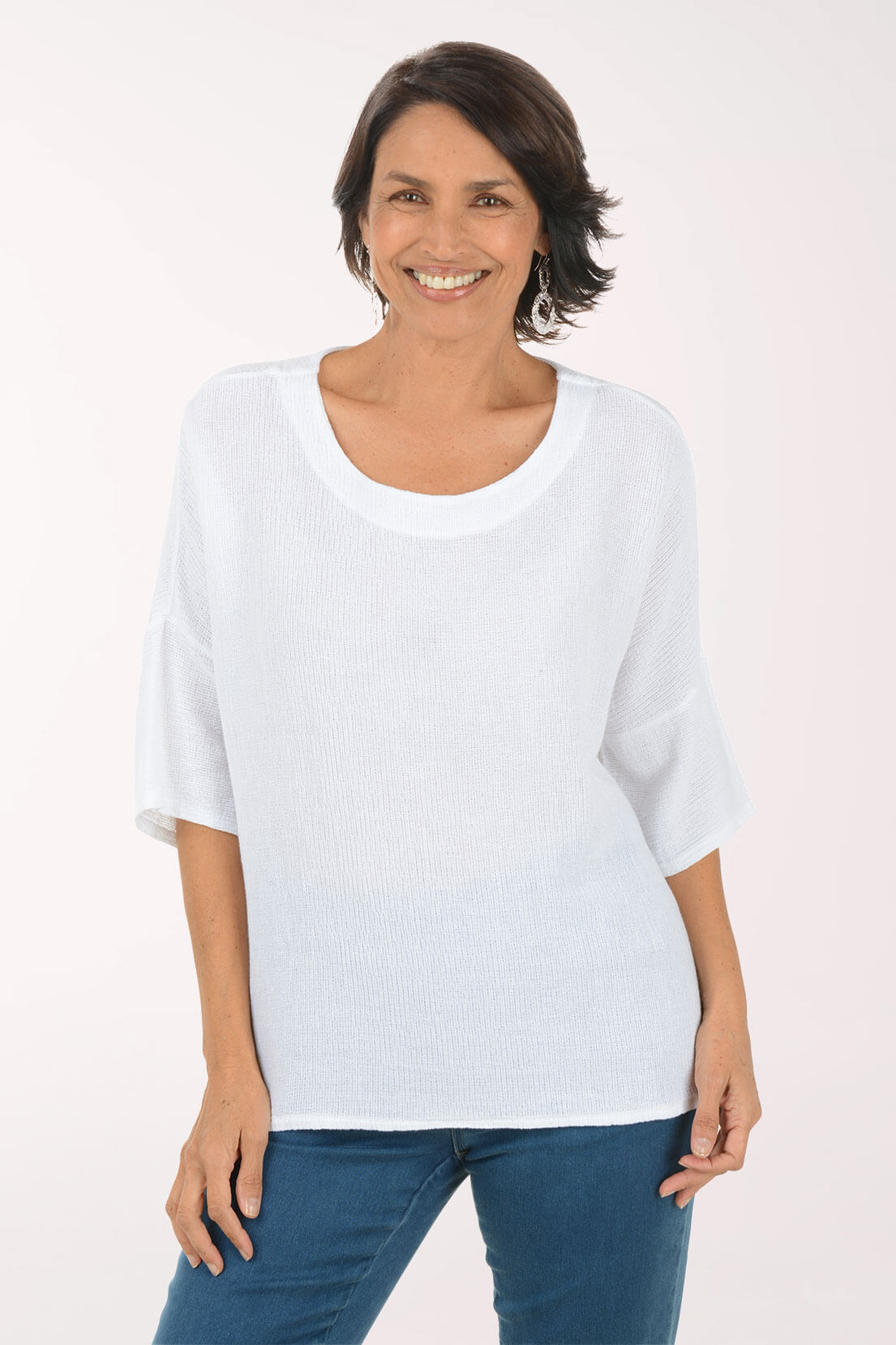 Woman wearing a white top and blue jeans on a white background