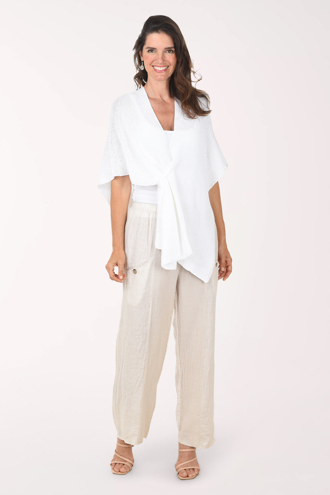 Woman wearing a white top and beige pants on a white background