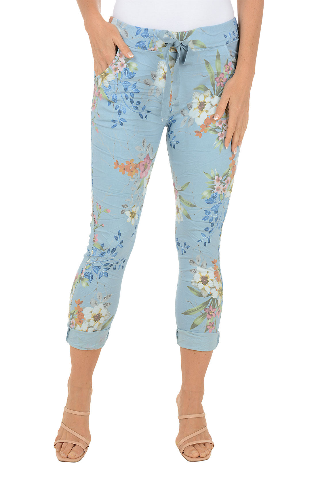 Light blue capri pants with floral pattern worn by a person on a white background.