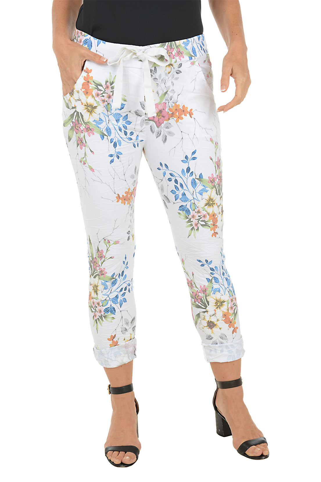 Floral-patterned pants worn by a person on a white background.