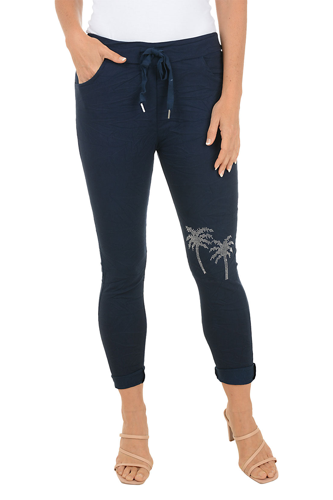 Navy blue pants with palm tree design on a white background.