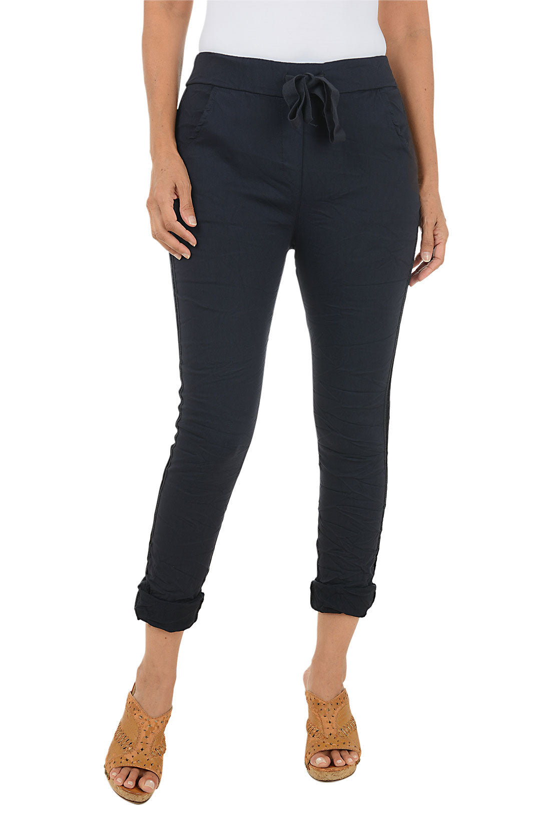 Person wearing navy blue pants with a white top on a white background.