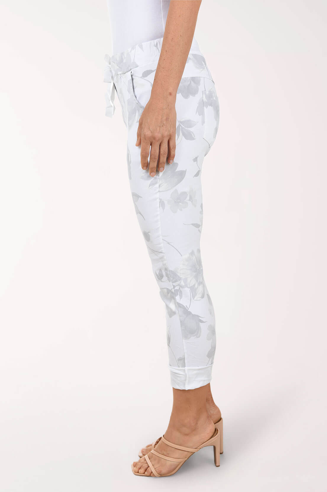 White floral-patterned pants worn by a person on a white background