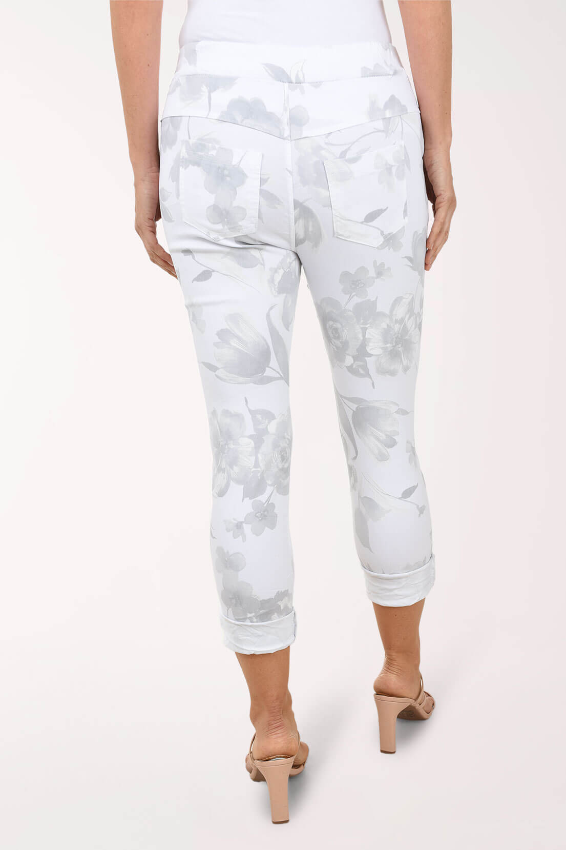 White pants with gray floral pattern worn by a person on a white background