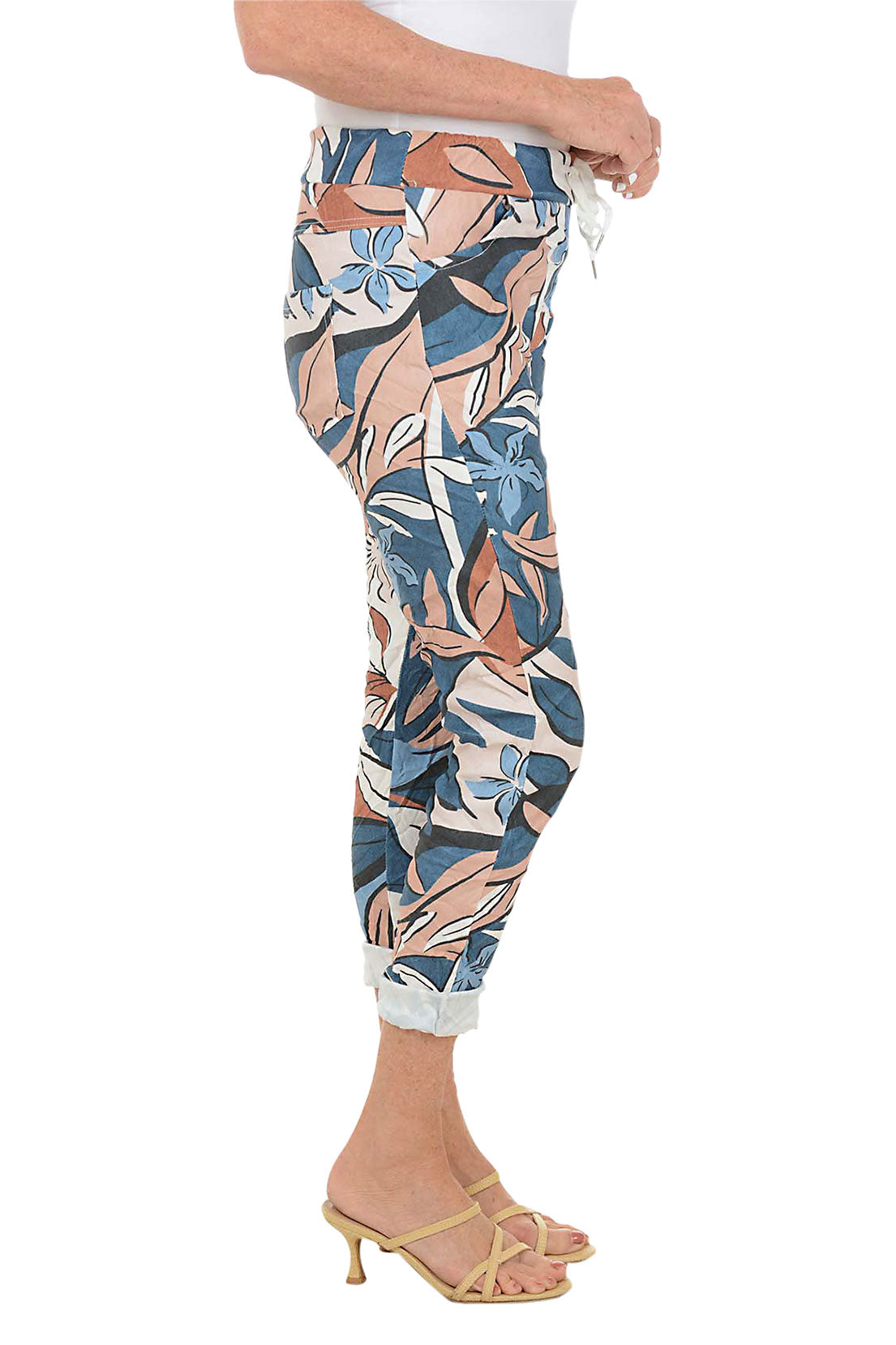 Multicolored floral-patterned pants worn by a person on a white background. Side shot.
