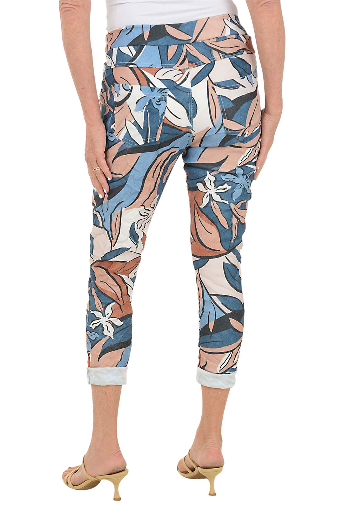 Multicolored floral-patterned pants worn by a person on a white background. Back shot.