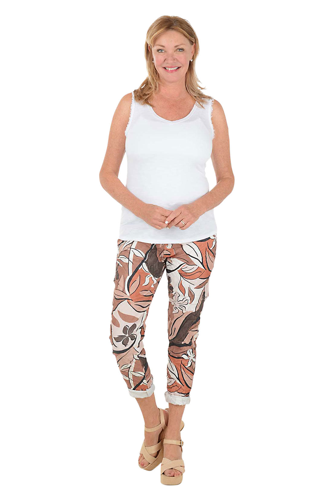Woman wearing a white tank top and patterned leggings on a white background