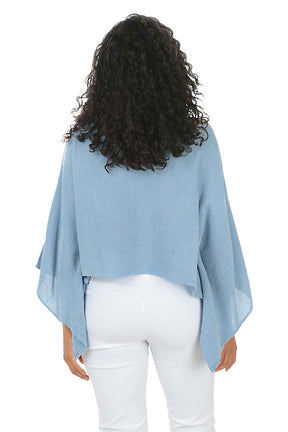 Woman wearing a blue sweater and white pants on a white background. Back shot.