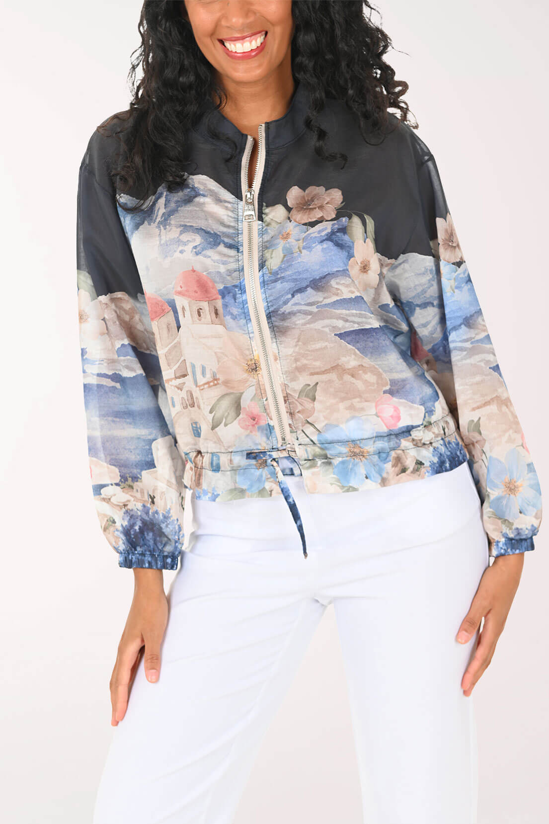 Woman wearing a colorful floral-patterned jacket with a black hood on a white background