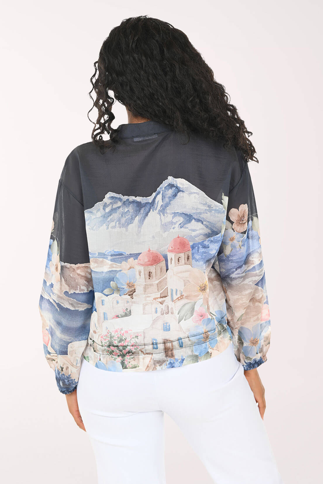 Person wearing a jacket with a scenic print on a white background