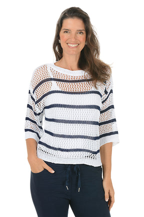 Woman wearing a white and navy striped sweater on a white background. Second front shot.