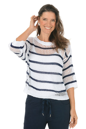 Woman wearing a white and navy striped sweater on a white background.