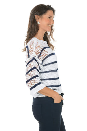 Woman wearing a white and navy striped sweater on a white background. Back shot.