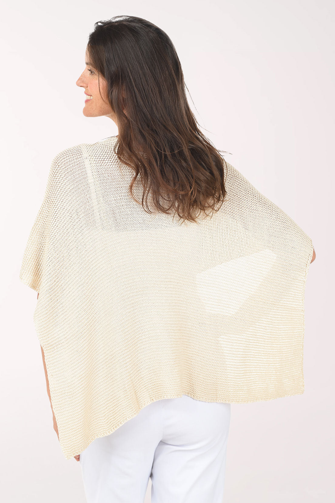 Woman wearing a beige knitted shawl on a white background