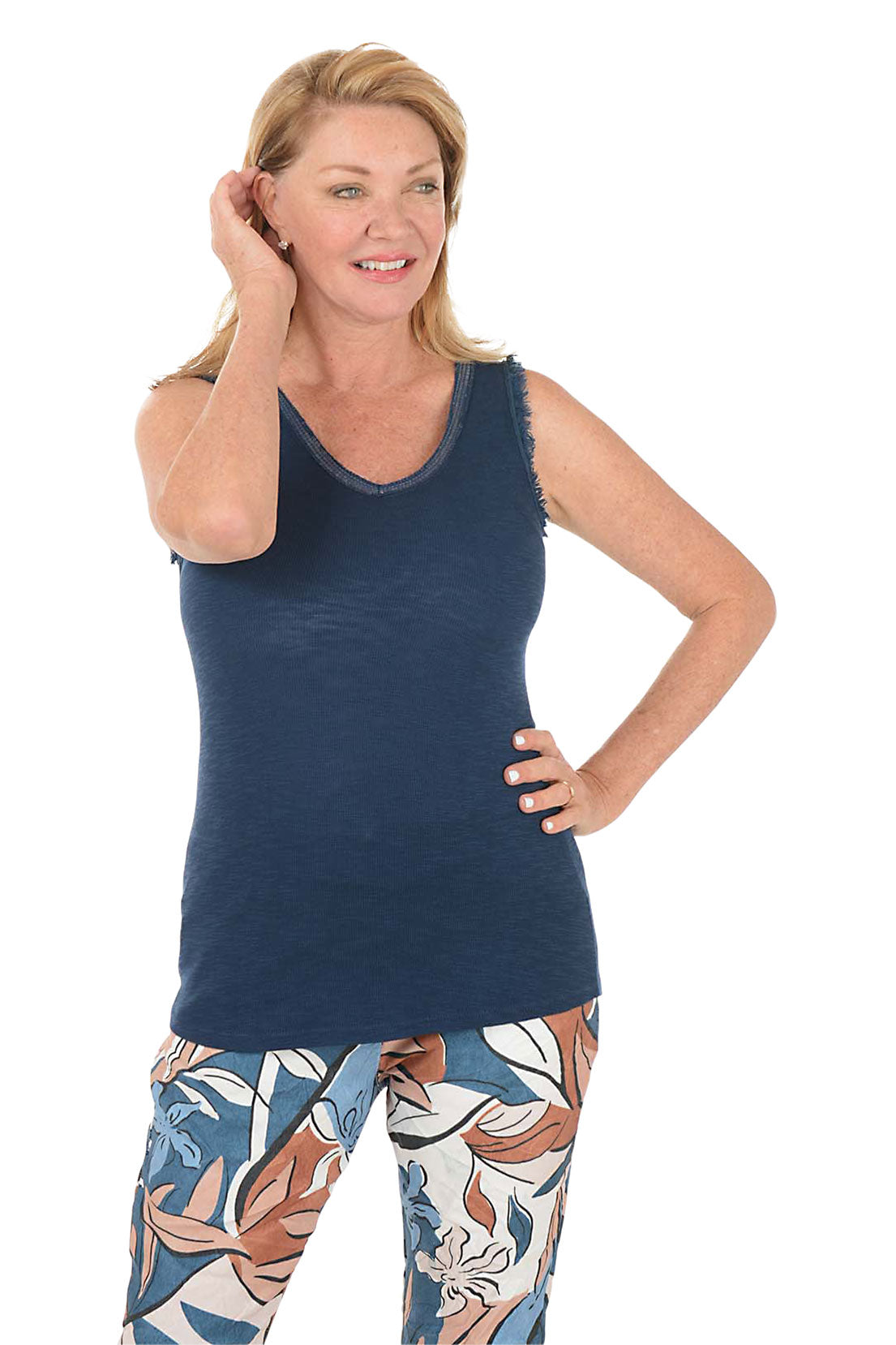 Woman wearing a navy tank top and patterned pants on a white background.