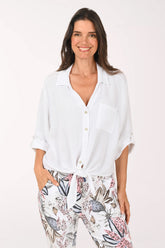 Woman wearing a white shirt and floral pants on a white background