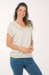 Woman wearing a short sleeve v-neck beige tee.