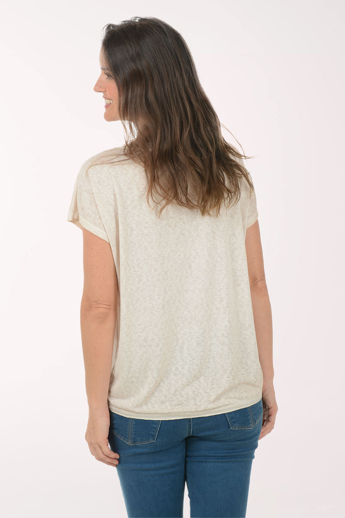Woman wearing a short sleeve v-neck beige tee.