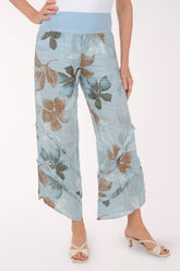 Woman wearing blue flowy pants with printed flowers.