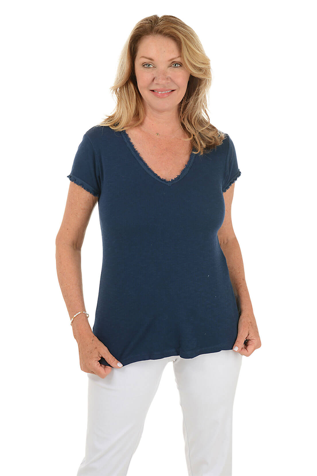 A front shot of a model wearing a navy V-neckline cotton t-shirt with short sleeves and a curved hemline. The t-shirt has frayed trim on the neck.