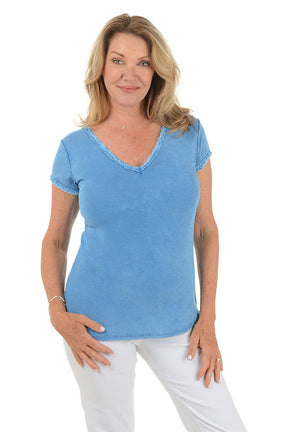 A front shot of a model wearing a royal V-neckline cotton t-shirt with short sleeves and a curved hemline. The t-shirt has frayed trim on the neck.
