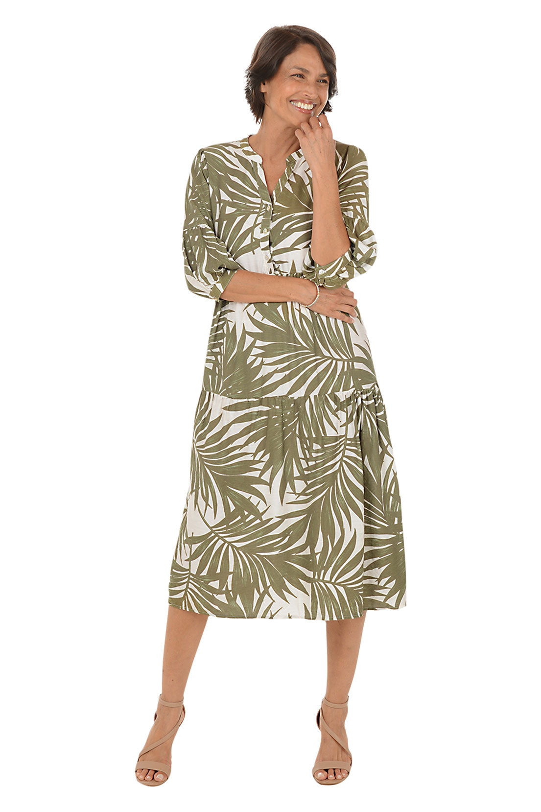 Woman wearing a green and white leaf-patterned dress on a white background. Second front shot.