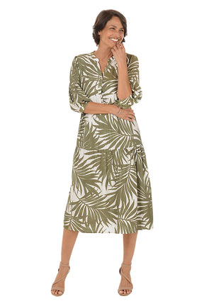 Woman wearing a green and white leaf-patterned dress on a white background. Second front shot.